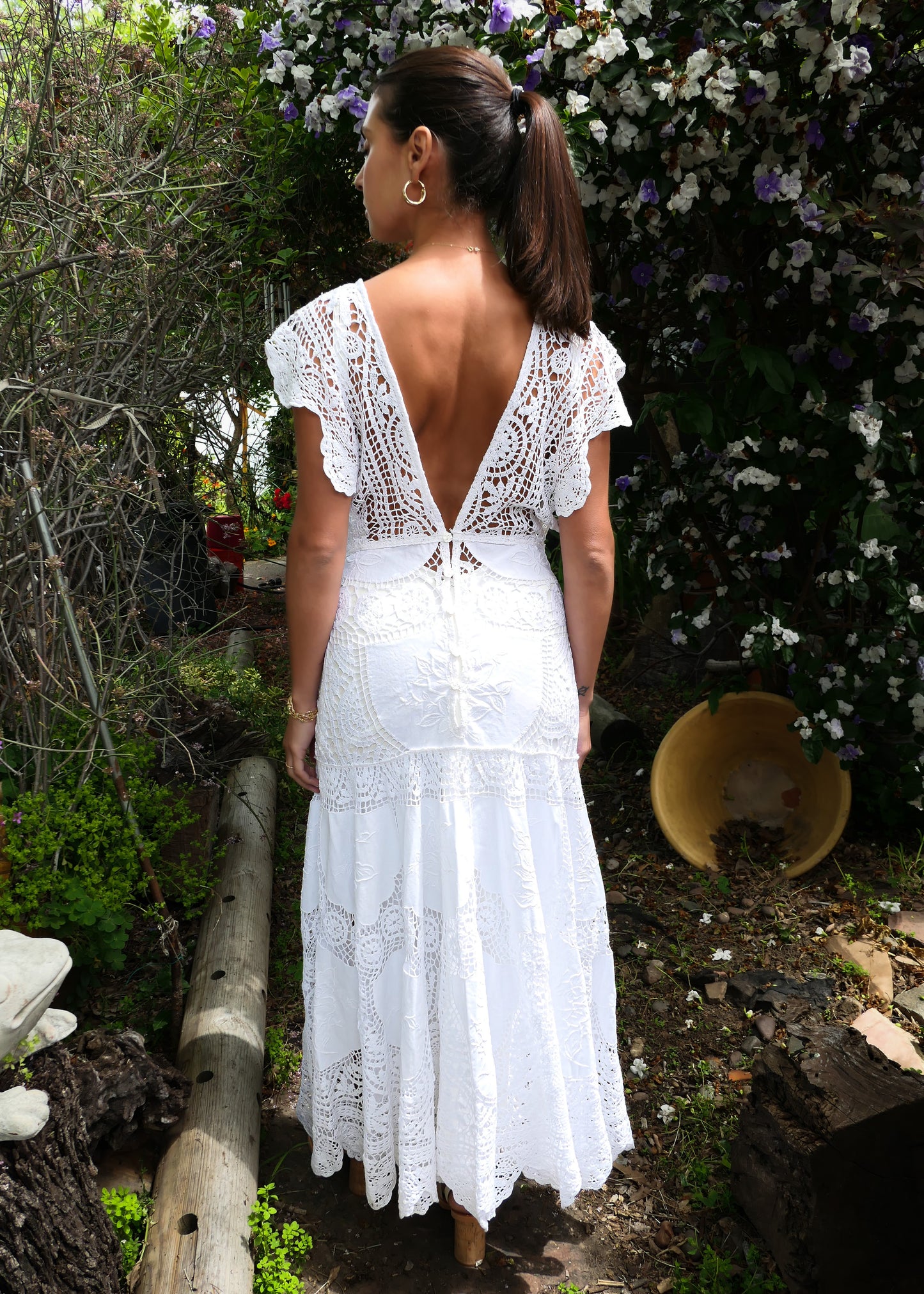 Back view of dress. A romantic and elegantly seductive V-neck and V-back hand crocheted and embroidered patchwork maxi dress made with our signature Lim's Vintage fabric. This dress is fitted and flared at all the right places, accentuating your natural curves and perfect for your special wedding day or stylish summer beach party. Does not come with a slip, but we highly recommend wearing one due to the "holey" nature of the crochet. Color: White. Can be made to order.