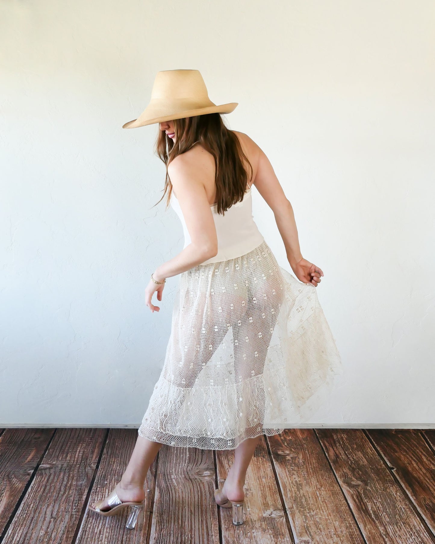 Like the delicate petals of the California Poppy, this skirt wafts and floats like a gentle summer breeze. Made with a delicate fishnet crochet, dotted with mini florettes, and accented with a two-tiered ruffle hem, this dress is sure to sweep you off your feet! Comes with a comfortable fitting elastic waistband that rests easily on the waist. Great as a beach coverup with a pair of wedgy sandals, a cute straw hat, and a mojito in hand. Size: Fits small to medium