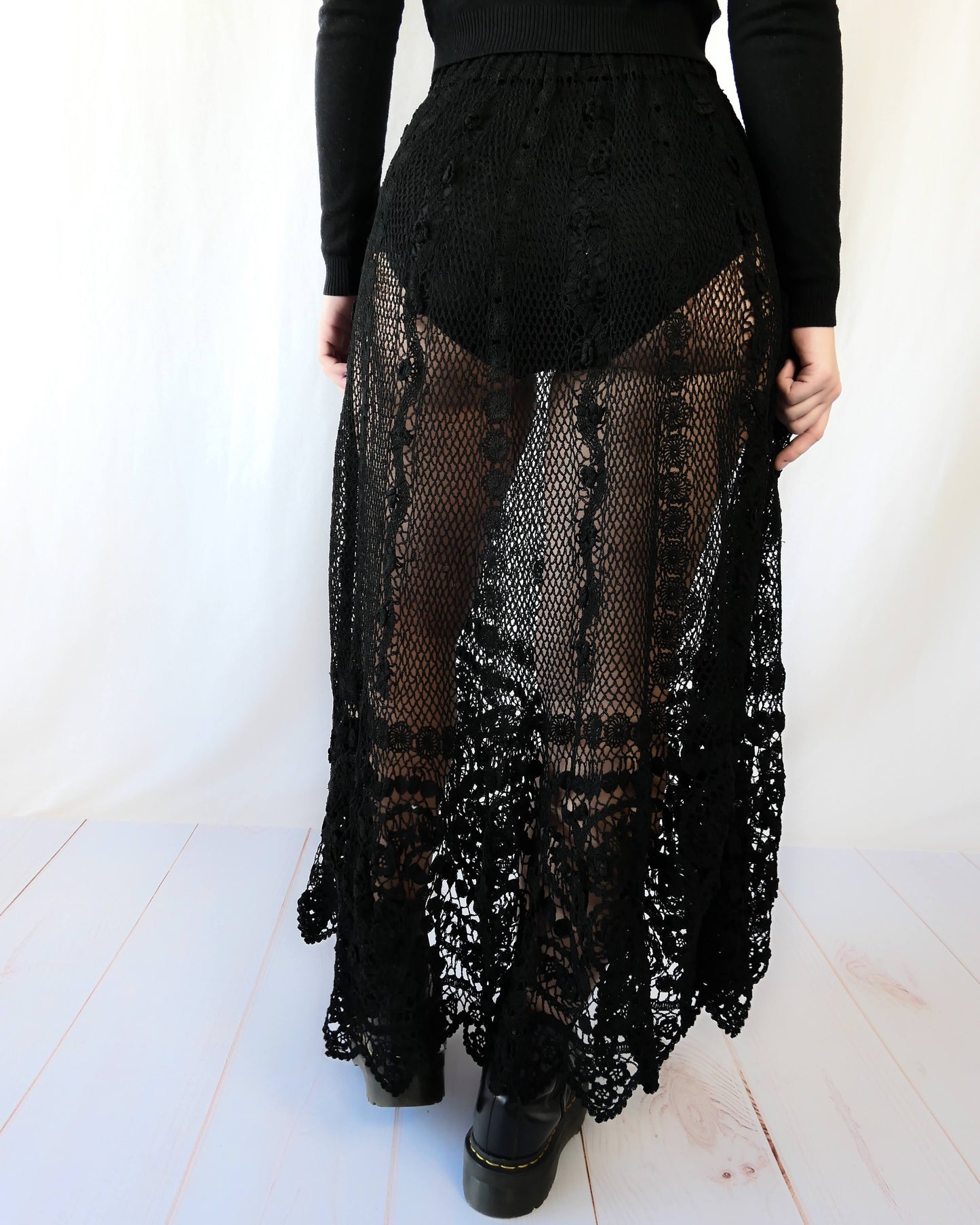 Fall in love again with this original Lim's bohemian, whimsical black hand crocheted, maxi length skirt. Lovely paisley motif at the bottom hem, with vertical lines throughout the dress composed of intricate pinwheel-like circles and squiggly lines dotted with flowers. Looks stunning paired with a black silk camisole and bikini shorts, or a black sweater or crop top and a pair of boots. Size: Fits Small to Medium Measurements: Waist 26"- 30" Length 38" Hip 55” Color: Black Material: 100% cotton