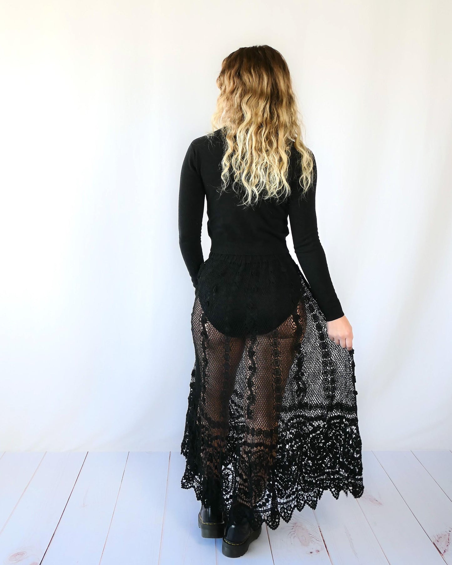 Fall in love again with this original Lim's bohemian, whimsical black hand crocheted, maxi length skirt. Lovely paisley motif at the bottom hem, with vertical lines throughout the dress composed of intricate pinwheel-like circles and squiggly lines dotted with flowers. Looks stunning paired with a black silk camisole and bikini shorts, or a black sweater or crop top and a pair of boots. Size: Fits Small to Medium Measurements: Waist 26"- 30" Length 38" Hip 55” Color: Black Material: 100% cotton