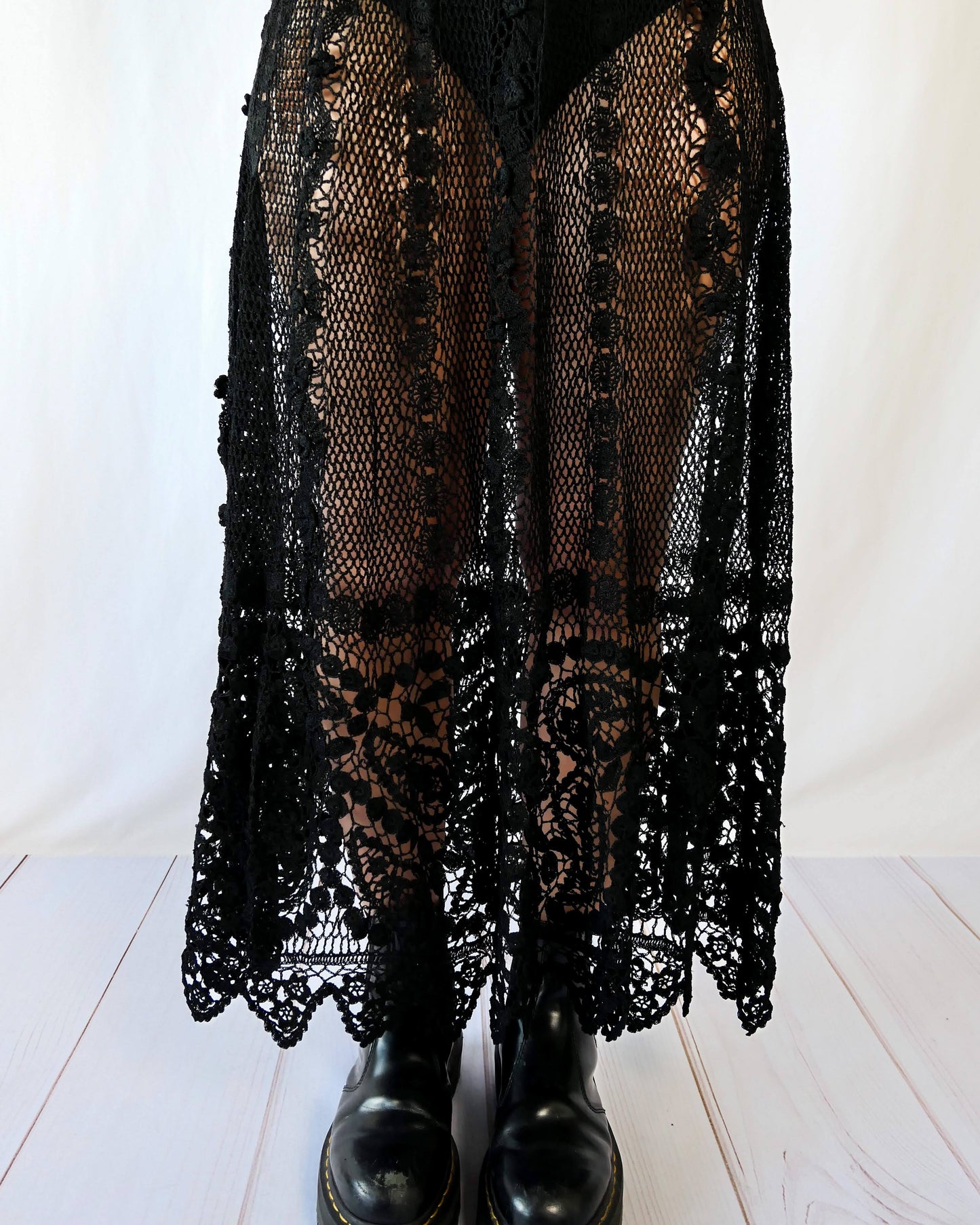 Fall in love again with this original Lim's bohemian, whimsical black hand crocheted, maxi length skirt. Lovely paisley motif at the bottom hem, with vertical lines throughout the dress composed of intricate pinwheel-like circles and squiggly lines dotted with flowers. Looks stunning paired with a black silk camisole and bikini shorts, or a black sweater or crop top and a pair of boots. Size: Fits Small to Medium Measurements: Waist 26"- 30" Length 38" Hip 55” Color: Black Material: 100% cotton