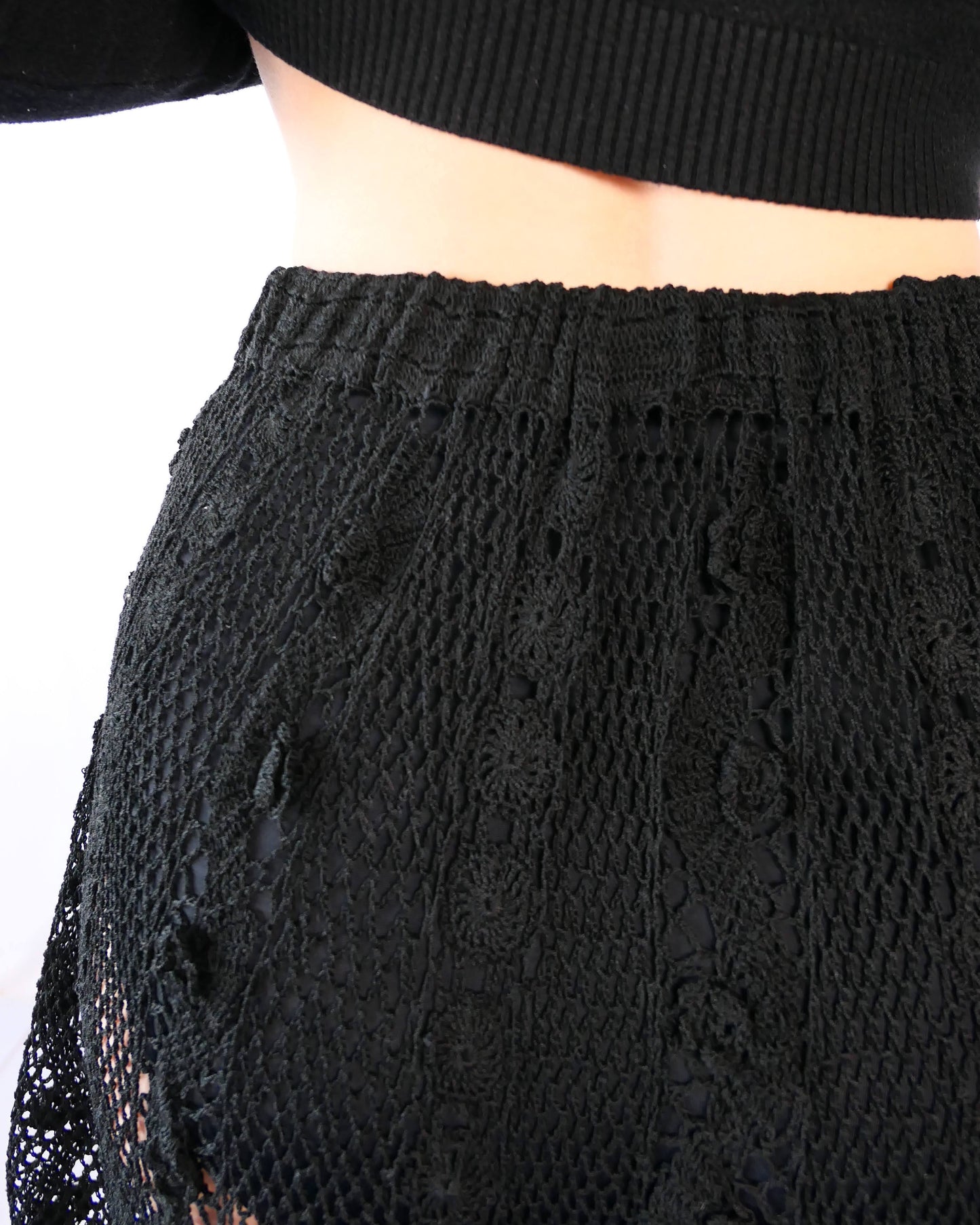 Fall in love again with this original Lim's bohemian, whimsical black hand crocheted, maxi length skirt. Lovely paisley motif at the bottom hem, with vertical lines throughout the dress composed of intricate pinwheel-like circles and squiggly lines dotted with flowers. Looks stunning paired with a black silk camisole and bikini shorts, or a black sweater or crop top and a pair of boots. Size: Fits Small to Medium Measurements: Waist 26"- 30" Length 38" Hip 55” Color: Black Material: 100% cotton