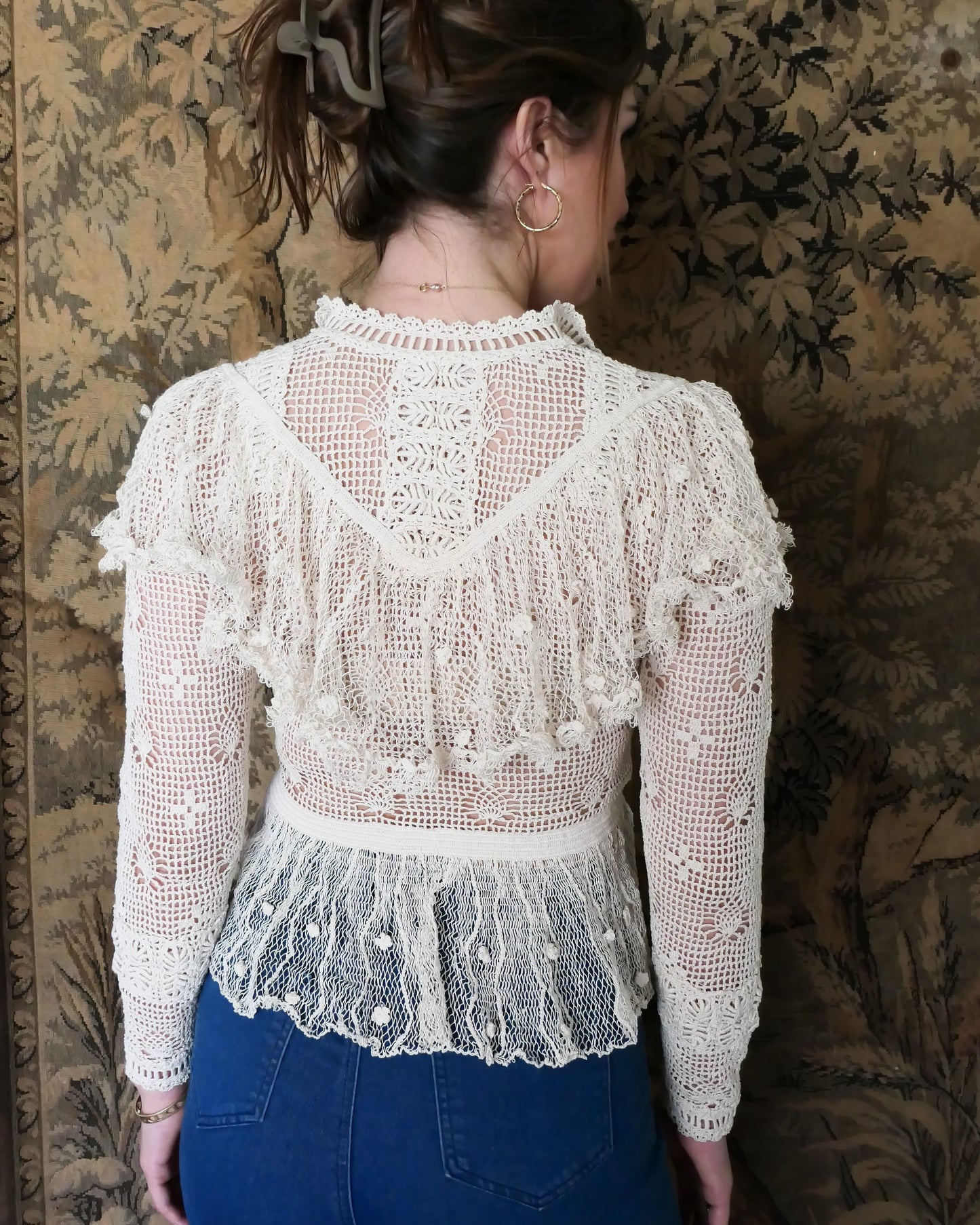 Closeup view of back of top when the buttons are worn in the front. Back view of Lim's Victorian crochet long sleeve top in Natural. Lim's original crochet top from the 1980s. Slightly thicker threads were used to crochet the body of the top, and very fine threads give the ruffled parts a lightweight, feminine touch. High Victorian neckline, a beautiful, intricate trim on the sleeves and chest, and a fitted waist and flared hem to create a flattering silhouette.