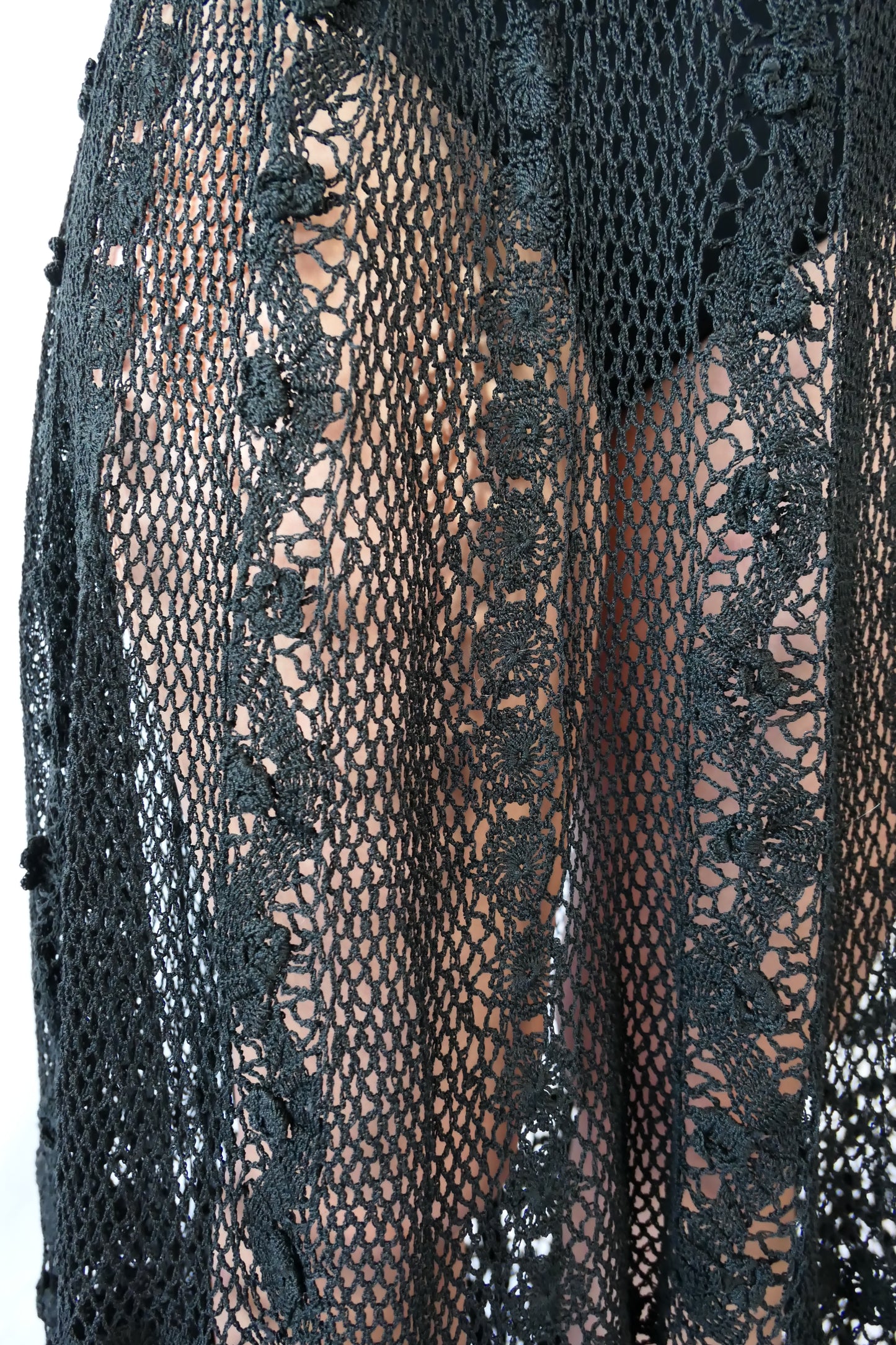 Fall in love again with this original Lim's bohemian, whimsical black hand crocheted, maxi length skirt. Lovely paisley motif at the bottom hem, with vertical lines throughout the dress composed of intricate pinwheel-like circles and squiggly lines dotted with flowers. Looks stunning paired with a black silk camisole and bikini shorts, or a black sweater or crop top and a pair of boots. Size: Fits Small to Medium Measurements: Waist 26"- 30" Length 38" Hip 55” Color: Black Material: 100% cotton