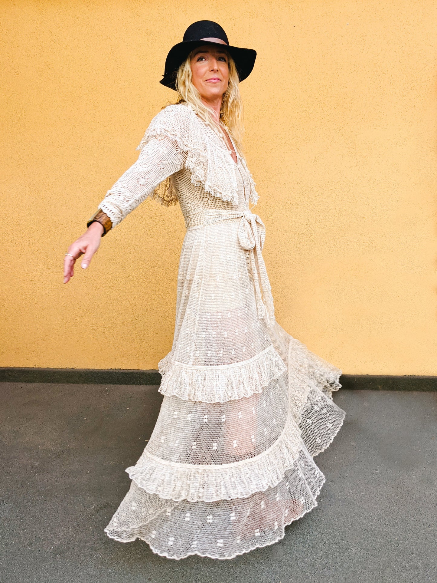 Our one-of-a-kind Lim's original hand crocheted maxi dress from the 1980s, worn by Jane Fonda and once even copied by a famous designer (who shall not be named here) and placed in a major fashion magazine ad. We have only two originals of this dress left in Small and Medium sizes. Ruffles around the collar line and a two-tiered ruffle at the bottom hem add a boho chic, feminine touch. The dress is reversible and can be worn with the buttons going up the front or back of the dress.