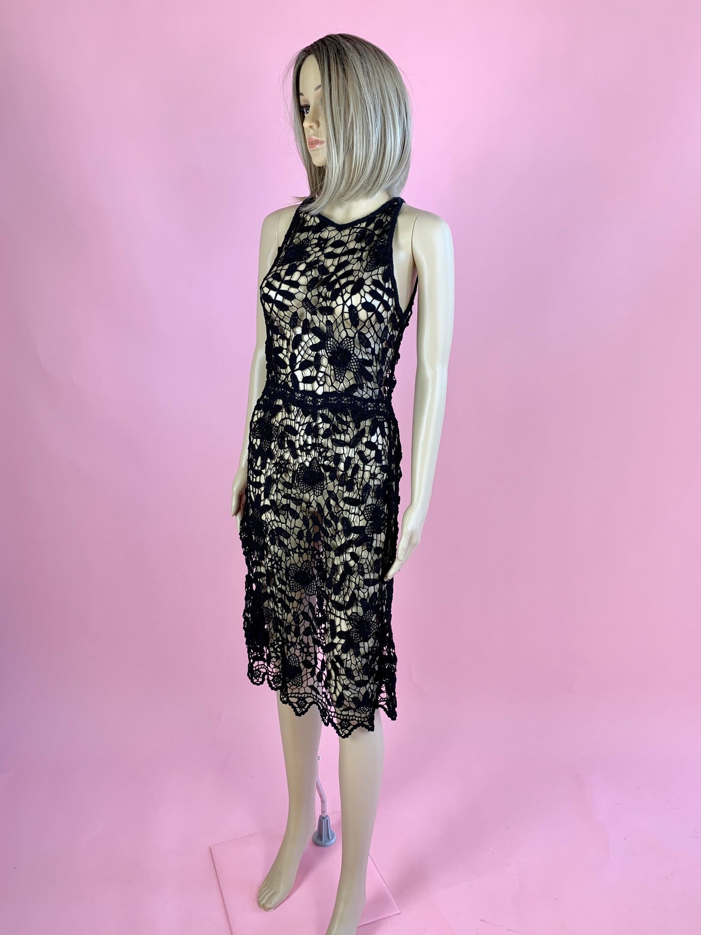 Lim's Vintage black crochet sleeveless halter midi dress with leaf and floral motif and zig-zag hem. The top is reversible and can be worn with buttons going down the front or back. Elastic waistband connects the top and bottom of the dress.