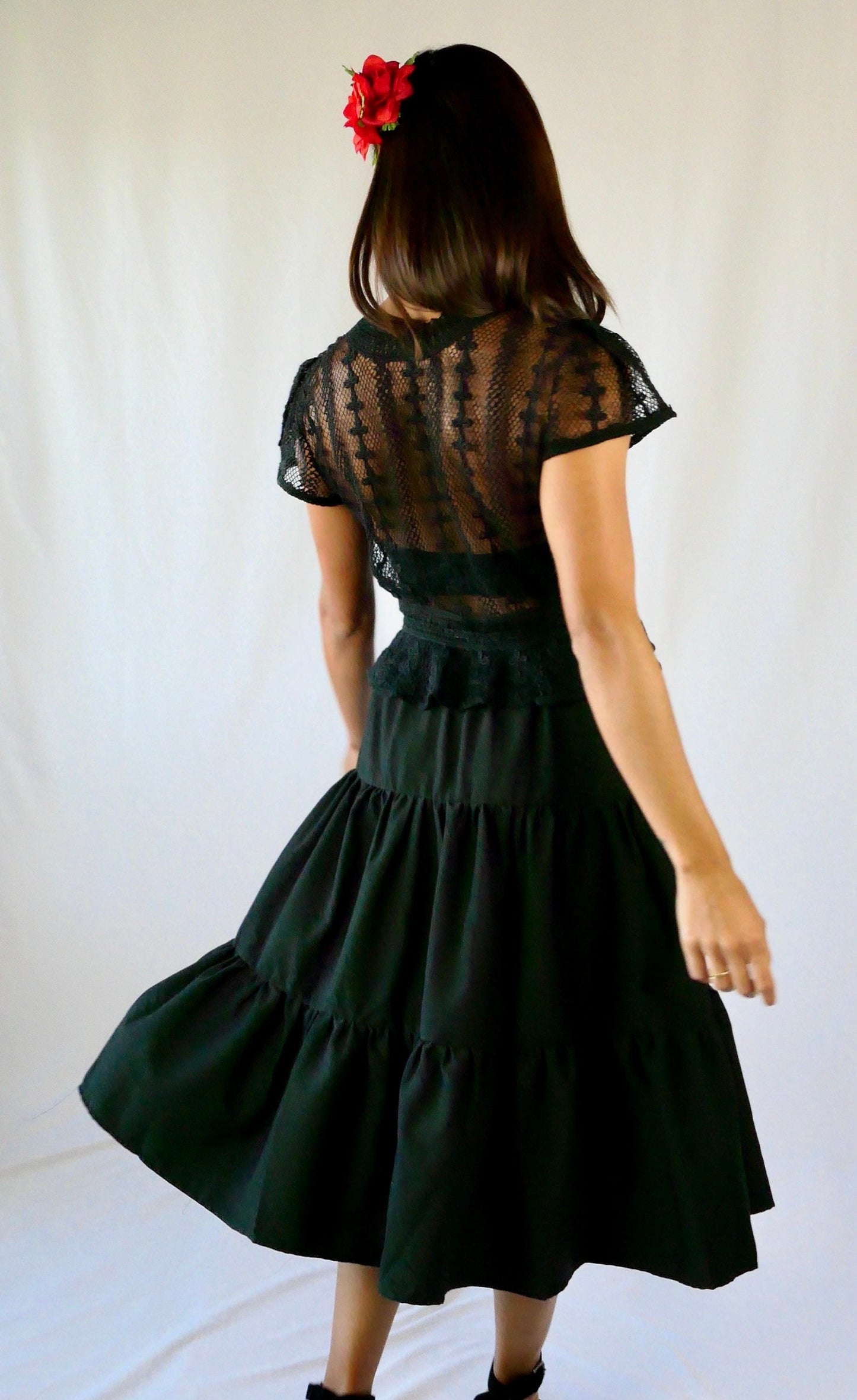 Delicate mesh pattern hand crocheted short puff sleeve top in black with a high waist and flared hem. This is a Lim’s original vintage piece from the 1980s with trim added recently to finish the hem. The top is reversible and can be buttoned up the front or back.