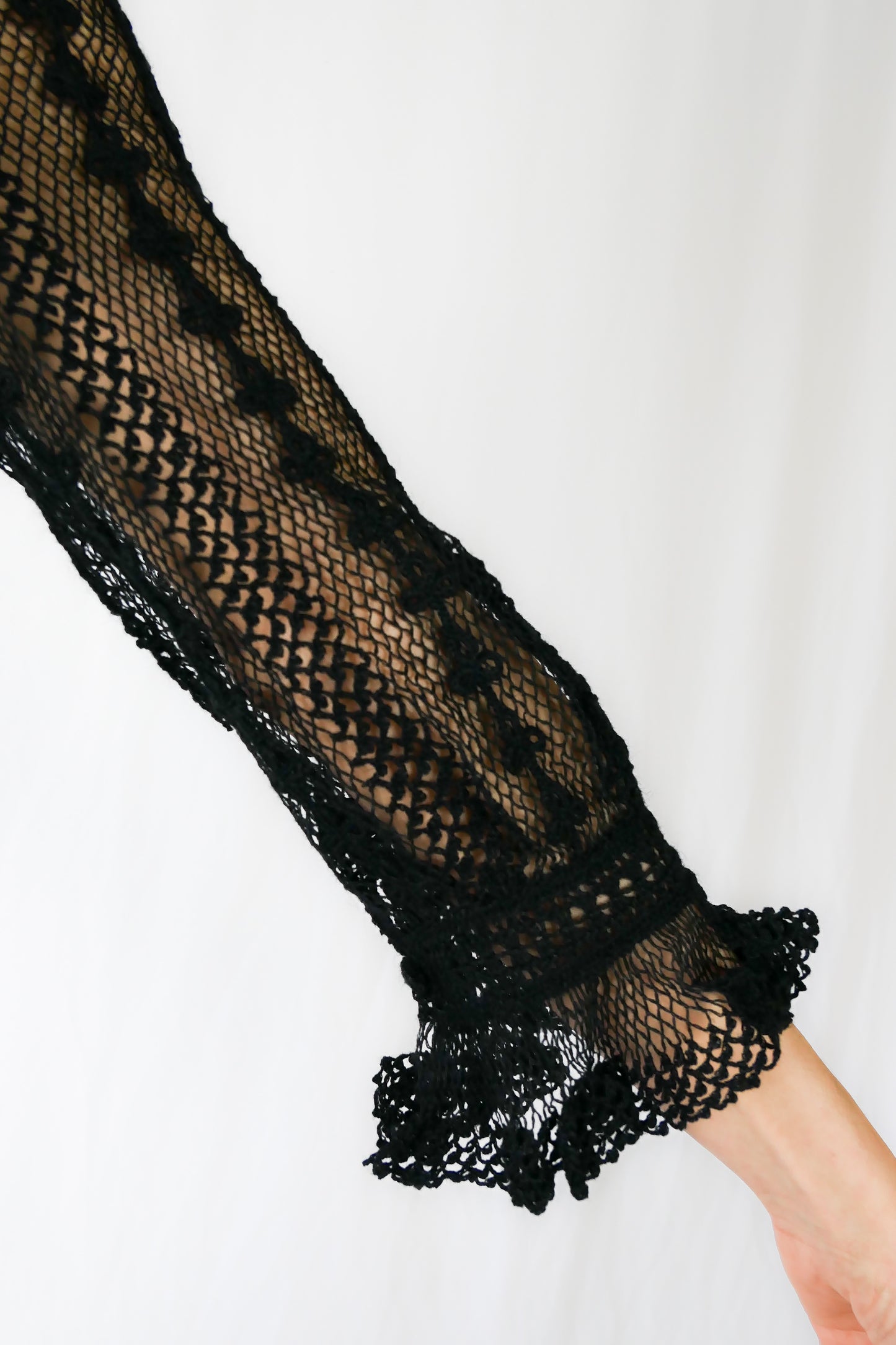 A beguiling black version of our cottage core style midi length crochet dress, this dreamy Lim's original vintage piece from the 1980s is made with very fine threads, creating a refined and sheer look. Detailed crochet trim is used at the waist, hemline, and 3/4 length ruffled sleeves. Measurements: Bust 36” Waist 30” Length 42” Shoulder width 15” Sleeve 20” Cuff circumference 9" Color: Black