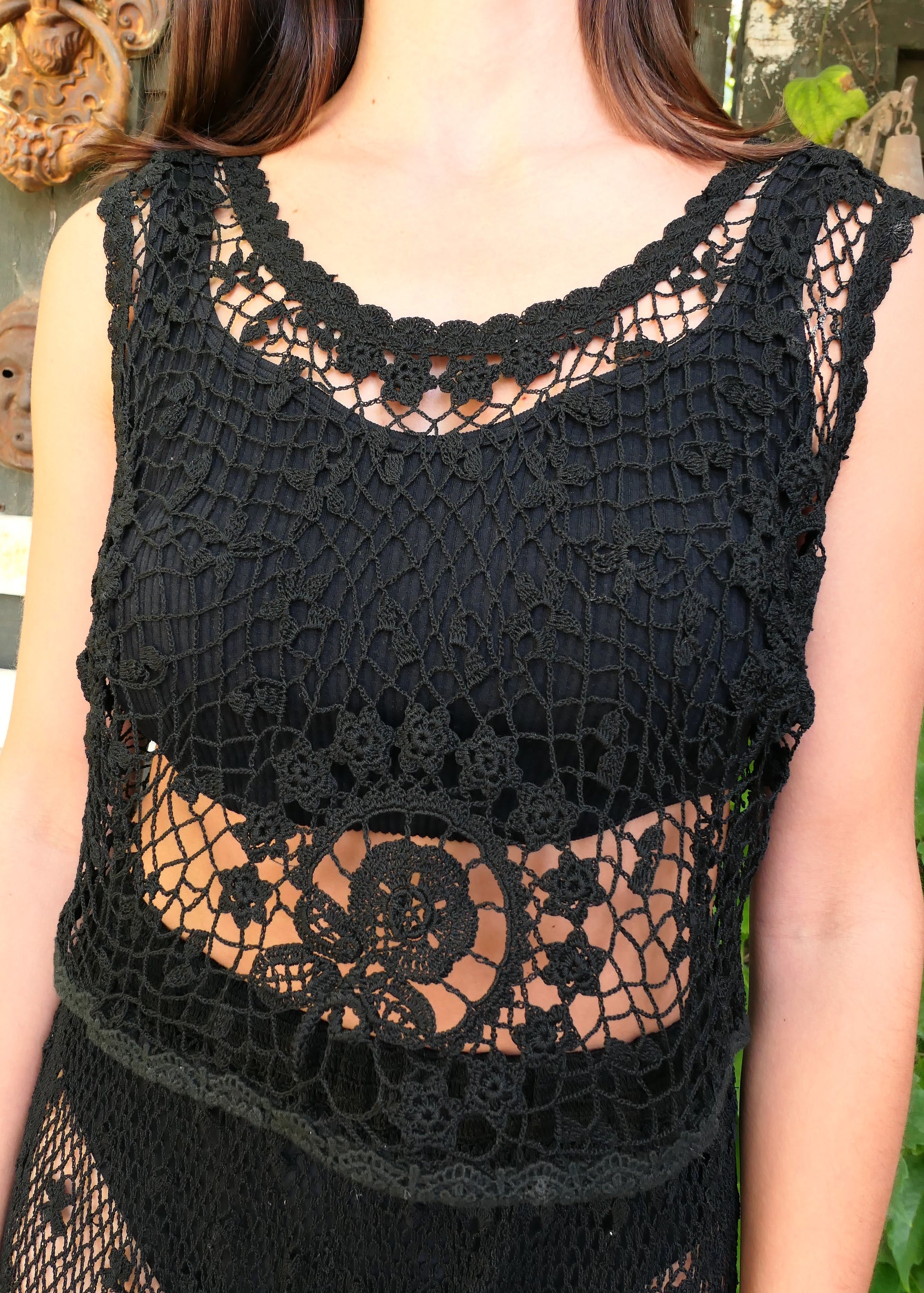 A Lim's Vintage hand crocheted sleeveless black tank top with a beautiful floral themed design motif. Both casual and elegant, with a timeless vintage feel, this versatile top can be worn over a simple black slip or bikini top and paired with just about anything. Color: Black, Size: Small to Medium