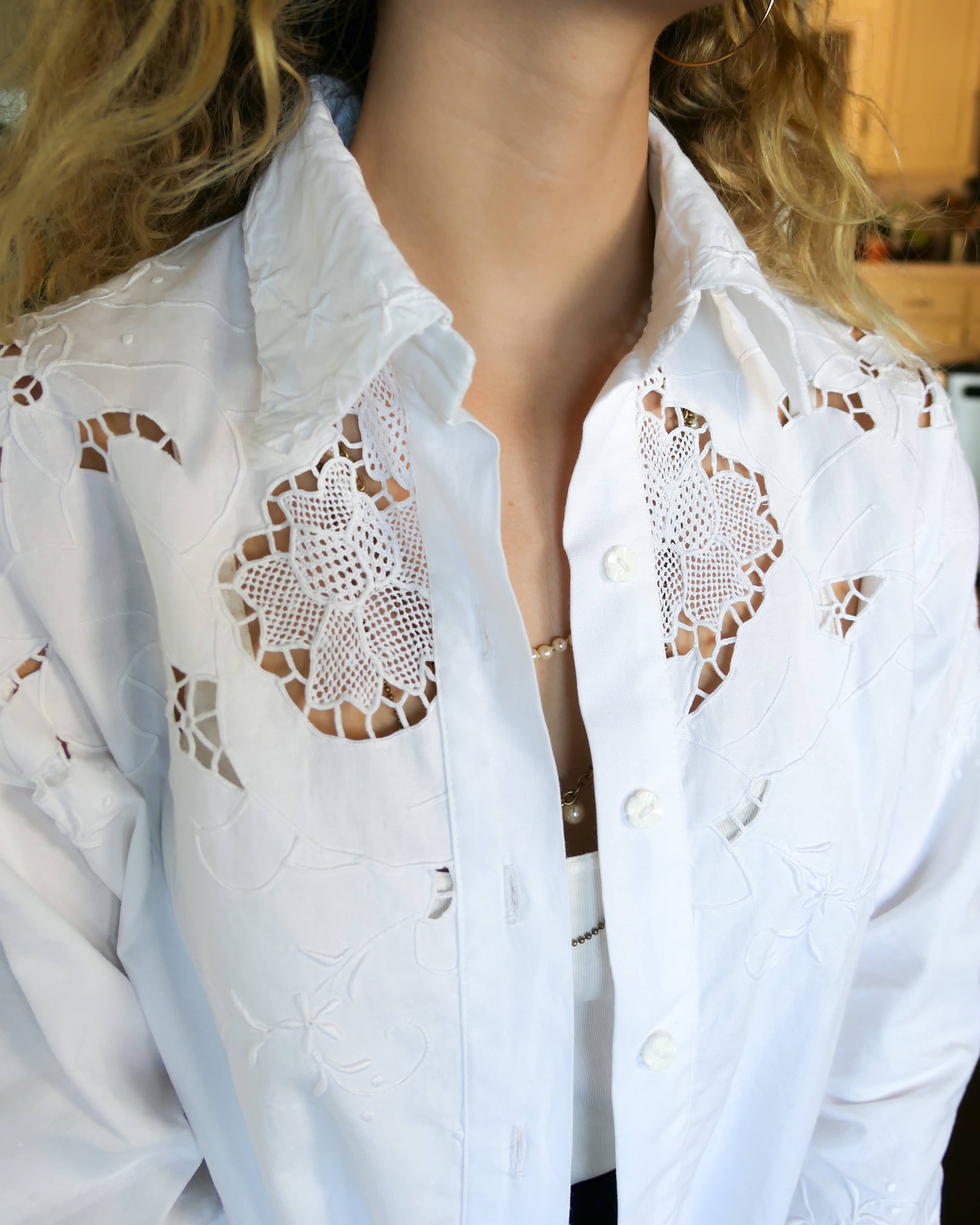 Uplift your everyday wardrobe with this cotton long sleeve shirt made with our vintage cutout and hand embroidered fabric. Embroidered and cutout detail in the collar, cuffs, and hemline make this shirt ultra-feminine and unique.  Note that the fabric is made with a thicker cotton fabric.  Comes in Small, Medium, and Large sizes.  