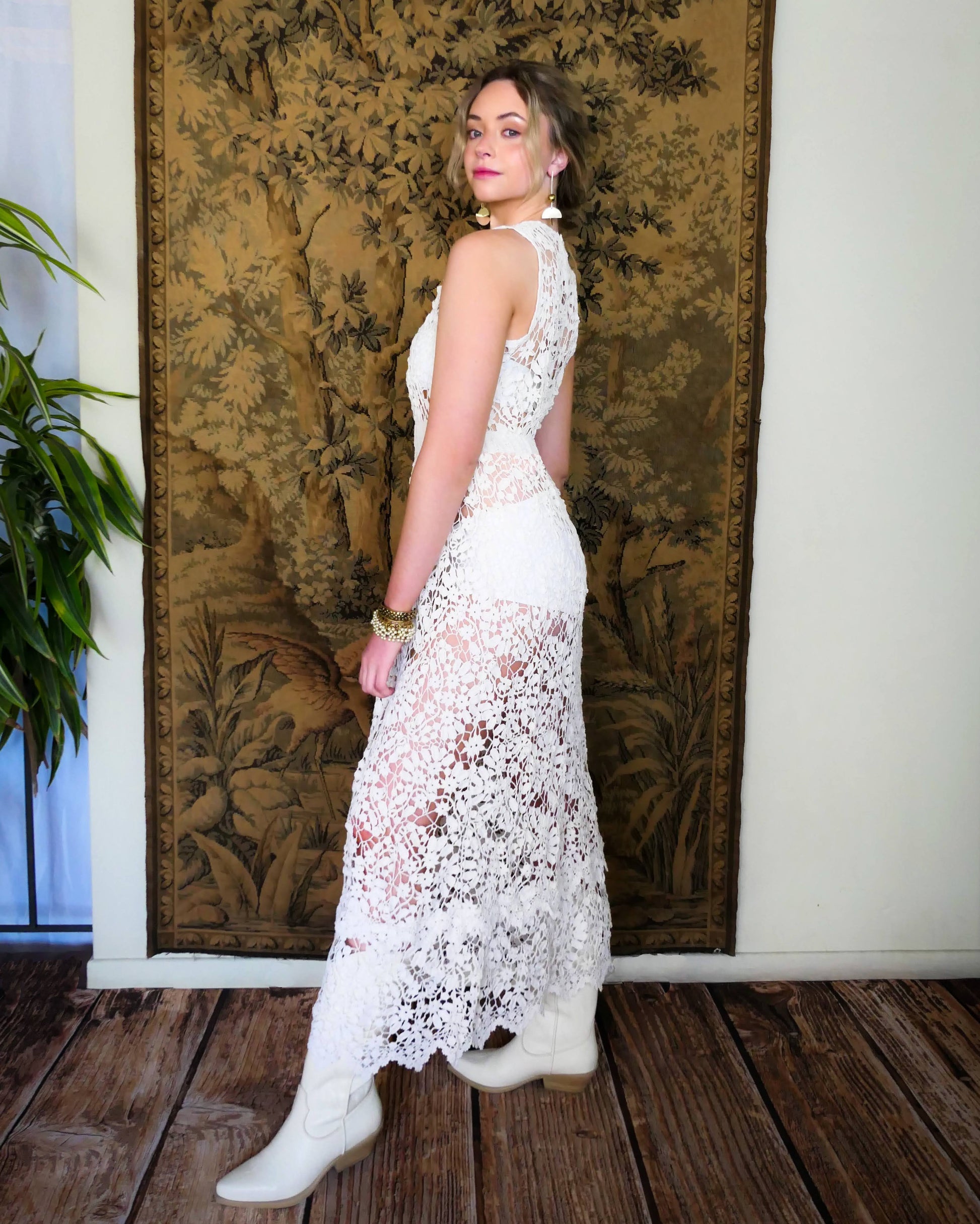 An easy pullover tank maxi dress in white, made with one of our signature Lim's Vintage hand crocheted fabrics that has a delicate floral and leaf motif throughout. The bottom of the dress has a double tiered hem, which adds length to the dress. Wear it with a chunky belt, white boots, and a simple white slip or bralette and bikini shorts on your next special outing.  