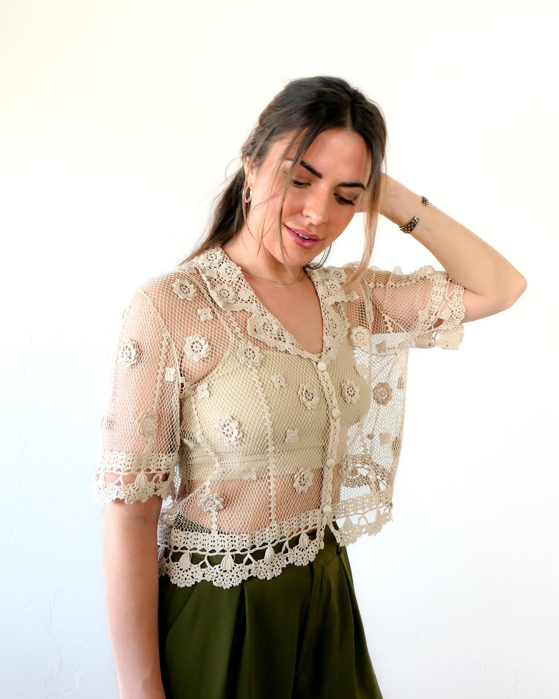 One of the last of our original Lim's hand crocheted half sleeve button down tops in Natural from the 1990s, this versatile, lightweight, sheer top with a notched collar and floral motif design is sure to catch a few eyes. Relaxed, easy fit with dainty, hand crocheted flowers throughout and a scalloped hem reminiscent of upside down carnations. Dress it up or down any way you like.