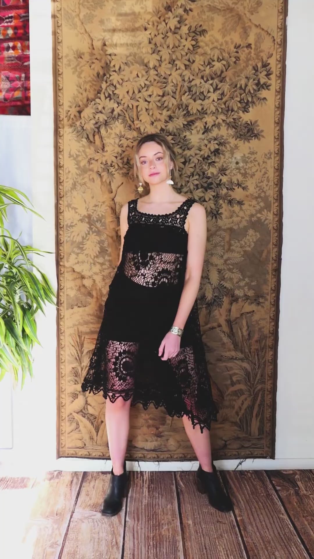 Video of model twirling around in black crochet babydoll style tank dress.  A sleeveless babydoll dress made from our Lim's Vintage original fishnet crochet fabric with a repeating floral themed design throughout. A versatile, comfortable, fun-to-twirl-around-in pullover dress that you can wear wherever you go. The area above the breast and under the armpits is elastic and stretchable, making the dress suitable for most sizes.  Color: Black, Size: One size fits most