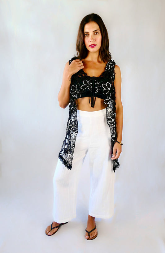 A One Size tie-up hand crocheted long vest with a playful black and white daisy flower motif throughout. Pair it with a strapless bikini bra, a pair of wide-leg trousers, and heels or sandals depending on your mood.  Made with original Lim's Vintage crochet fabric. 
