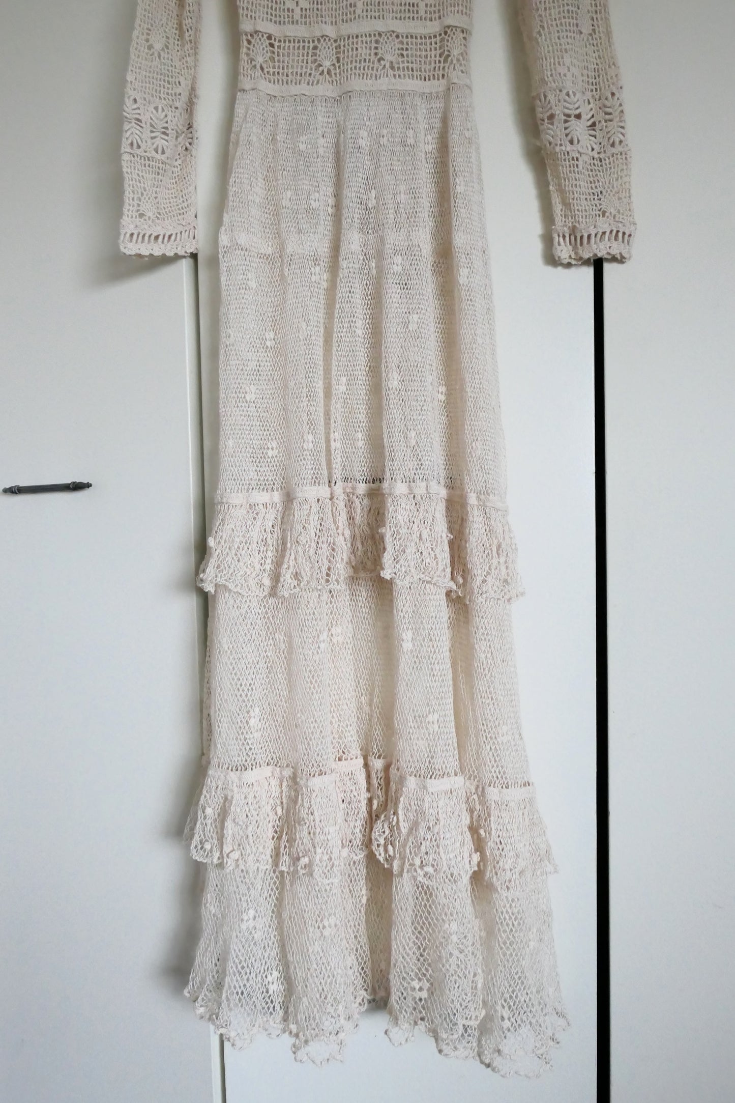 Our one-of-a-kind Lim's original hand crocheted maxi dress from the 1980s, worn by Jane Fonda and once even copied by a famous designer (who shall not be named here) and placed in a major fashion magazine ad. We have only two originals of this dress left in Small and Medium sizes.  Ruffles around the collar line and a two-tiered ruffle at the bottom hem add a boho chic, feminine touch.  The dress is reversible and can be worn with the buttons going up the front or back of the dress.