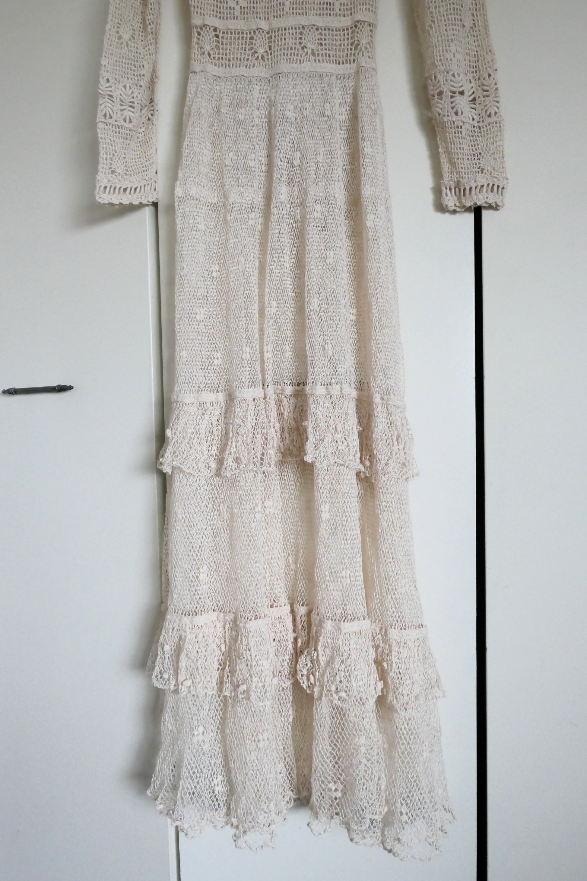 Our one-of-a-kind Lim's original hand crocheted maxi dress from the 1980s, worn by Jane Fonda and once even copied by a famous designer (who shall not be named here) and placed in a major fashion magazine ad. We have only two originals of this dress left in Small and Medium sizes.  Ruffles around the collar line and a two-tiered ruffle at the bottom hem add a boho chic, feminine touch.  The dress is reversible and can be worn with the buttons going up the front or back of the dress.