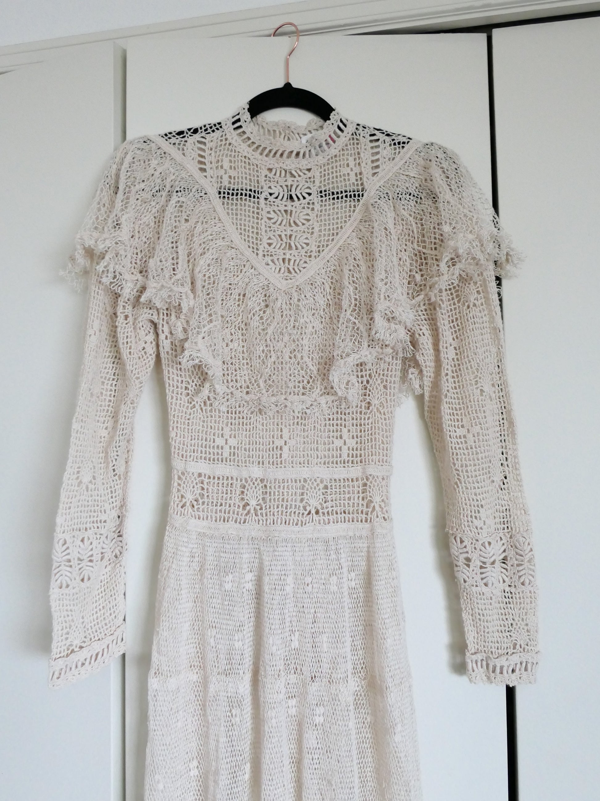 Our one-of-a-kind Lim's original hand crocheted maxi dress from the 1980s, worn by Jane Fonda and once even copied by a famous designer (who shall not be named here) and placed in a major fashion magazine ad. We have only two originals of this dress left in Small and Medium sizes.  Ruffles around the collar line and a two-tiered ruffle at the bottom hem add a boho chic, feminine touch.  The dress is reversible and can be worn with the buttons going up the front or back of the dress.