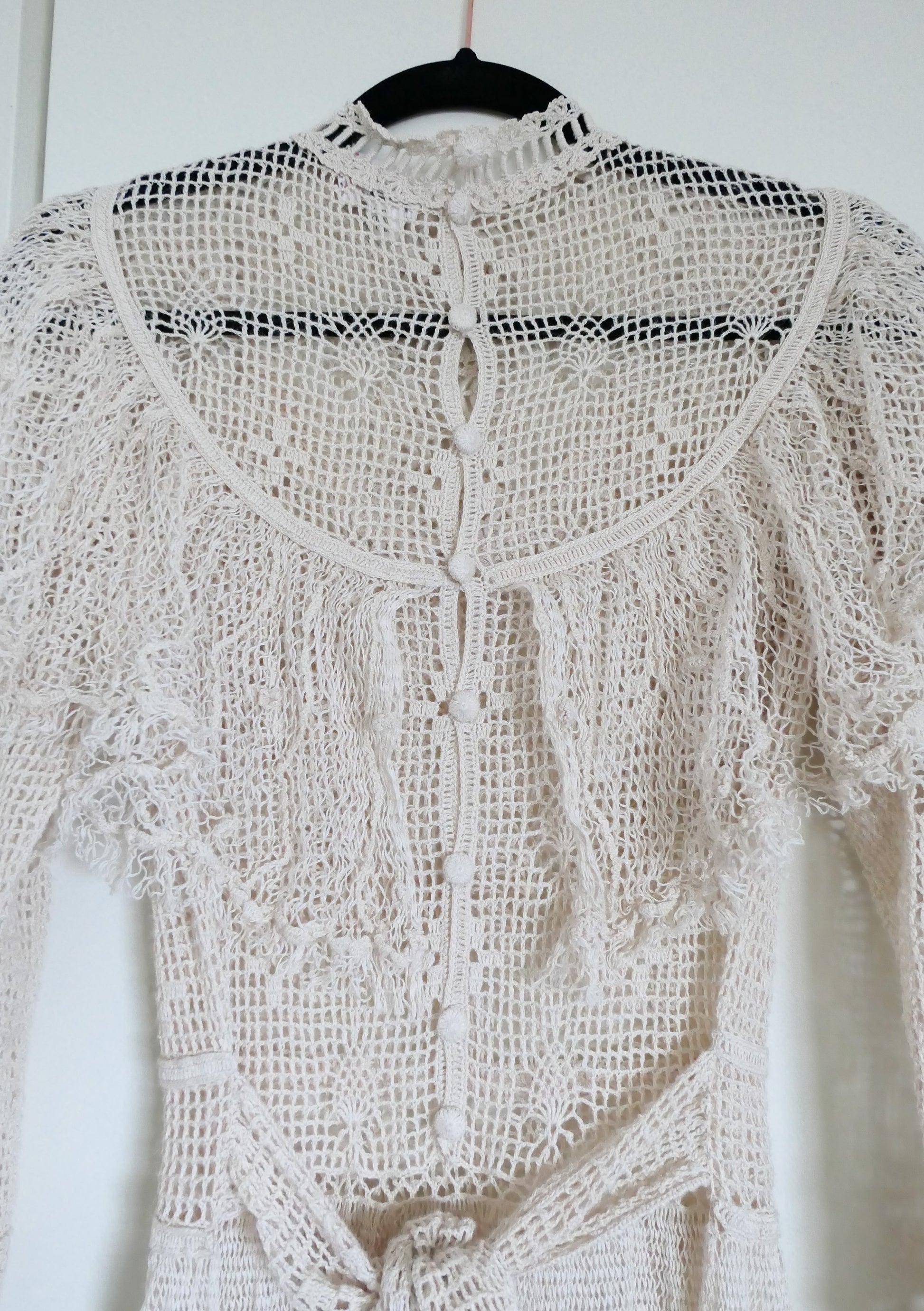 Our one-of-a-kind Lim's original hand crocheted maxi dress from the 1980s, worn by Jane Fonda and once even copied by a famous designer (who shall not be named here) and placed in a major fashion magazine ad. We have only two originals of this dress left in Small and Medium sizes.  Ruffles around the collar line and a two-tiered ruffle at the bottom hem add a boho chic, feminine touch.  The dress is reversible and can be worn with the buttons going up the front or back of the dress.
