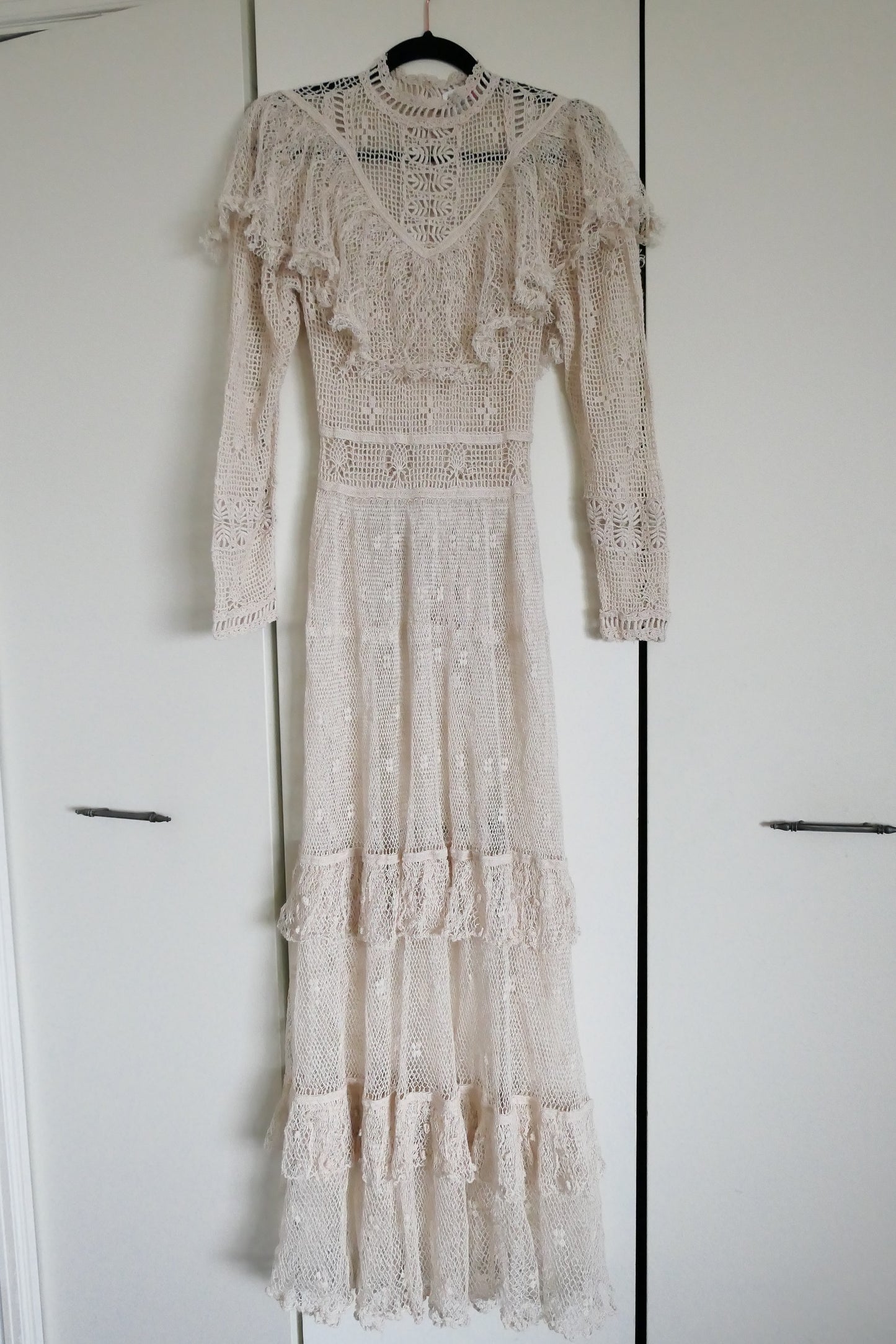 Our one-of-a-kind Lim's original hand crocheted maxi dress from the 1980s, worn by Jane Fonda and once even copied by a famous designer (who shall not be named here) and placed in a major fashion magazine ad. We have only two originals of this dress left in Small and Medium sizes.  Ruffles around the collar line and a two-tiered ruffle at the bottom hem add a boho chic, feminine touch.  The dress is reversible and can be worn with the buttons going up the front or back of the dress.