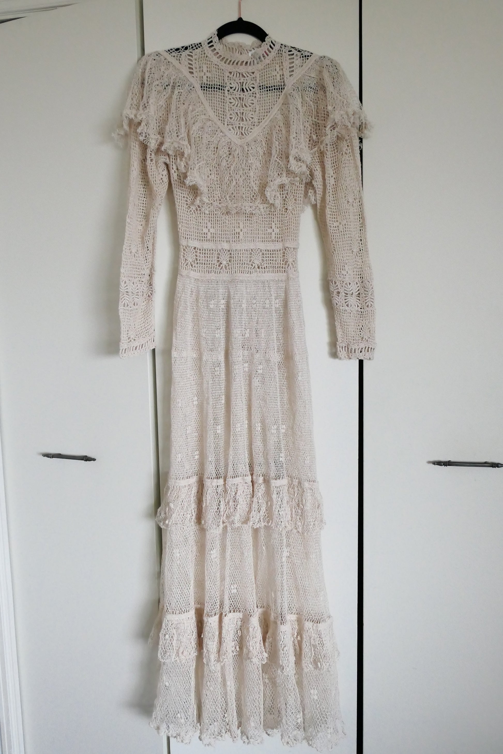 Our one-of-a-kind Lim's original hand crocheted maxi dress from the 1980s, worn by Jane Fonda and once even copied by a famous designer (who shall not be named here) and placed in a major fashion magazine ad. We have only two originals of this dress left in Small and Medium sizes.  Ruffles around the collar line and a two-tiered ruffle at the bottom hem add a boho chic, feminine touch.  The dress is reversible and can be worn with the buttons going up the front or back of the dress.